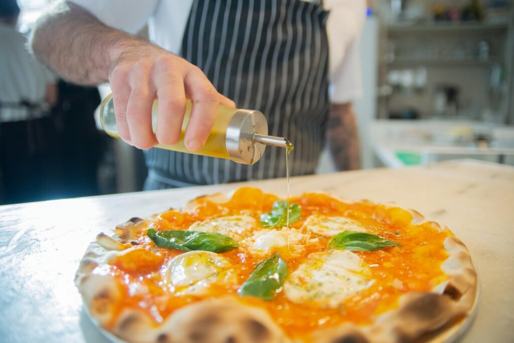 Chef pouring a gallon of olive oil for meal preparation